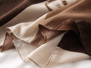 Detail of silk-like cotton-linen scarf showing belt buckle prints and rolled hem edges