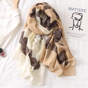 Detail of light beige floral scarf showing soft cotton-linen texture and large flower prints