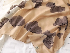 Detail of light brown floral print scarf with fine cotton-linen texture and large flower motifs