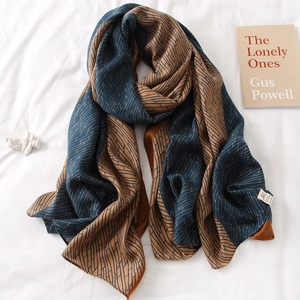 Navy blue and caramel geometric cotton linen feel large scarf in an artistic flat lay setting