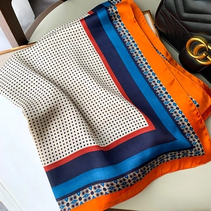 Dettaglio foulard in seta con pois e bordi vivaci arancione e blu scuro elegante