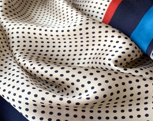 Dettaglio macro dello scialle in seta con pois e strisce tricolori in lucentezza satin