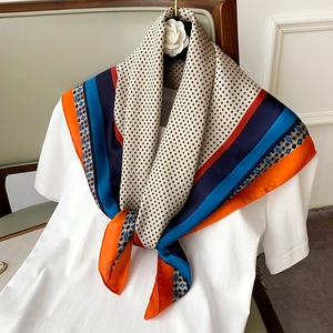Elegante sciarpa in seta con motivo paisley e blocchi di colore su camicia bianca
