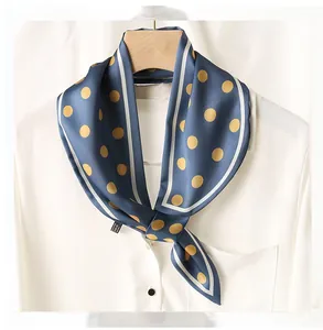 Détail d'un foulard étroit en soie à pois bleus avec chemise blanche et cintre en bois