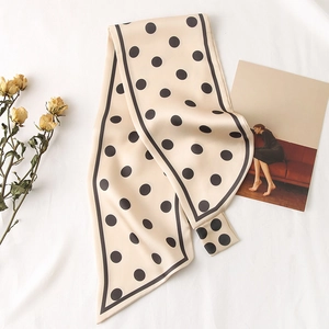 Gros plan d'un foulard en soie à pois vintage sur lin avec des roses séchées et cartes