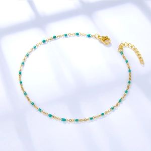 Golden stainless steel anklet with green beads and adjustable chain on white background