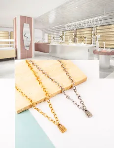 Macro detail of gold and silver thick chain necklaces with crystal-encrusted lock pendants