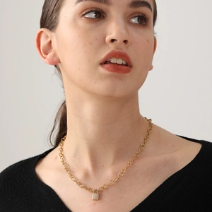 Golden lock pendant necklace with pave crystals on chunky chain worn by model