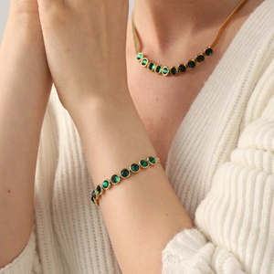 Retro Goldschmuck-Set mit grüner Edelsteinkette und Armband, präsentiert an einem Model