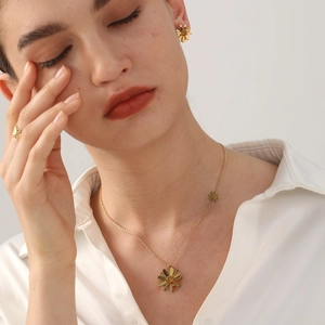 Parure de bijoux marguerite dorée avec pierres ambrées portée par un mannequin