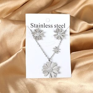 Détails macro de l'ensemble bijoux marguerite en acier et cristaux sur soie dorée