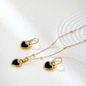 Parure de bijoux en or avec pendentifs cœur noirs et bords texturés soleil élégants