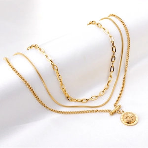 Three-layer gold 18K plated necklace with North Star compass pendant on white silk fabric