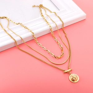 Macro detail of layered 18K gold necklaces featuring starburst pendant and Roman numerals