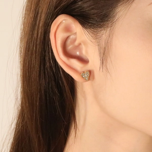 Golden heart stud earrings with sparkling pave zircon stones worn on earlobe