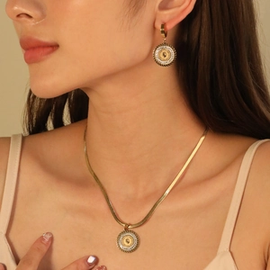 Detail of vintage coin pendant necklace and matching earrings set on gold snake chain