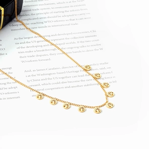 Detail shot of golden stainless steel necklace with nine hollow Tree of Life charms