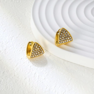 Vue détaillée de boucles d'oreilles triangulaires dorées ornées de zircons blancs