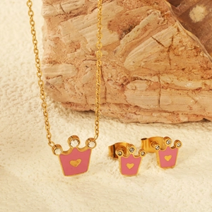 Détail d'un ensemble de bijoux couronne rose avec zircons sur un support en pierre brute