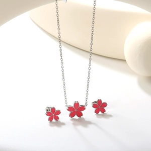 Détail de parure bijoux fleurs de cerisier roses avec pendentif couronne et boucles