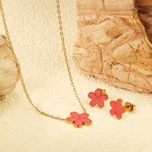 Vue détaillée de l'ensemble de bijoux fleurs en émail rose avec collier et boucles