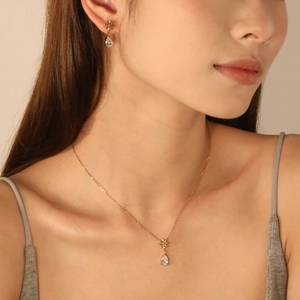 Set elegante collana a fiori dorati e orecchini in zircone a goccia su modella