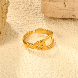 Detail of gold-plated adjustable ring with twisted line design on a textured stone base