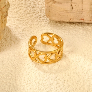 Detailed view of the polished golden open ring featuring a continuous hollow heart pattern