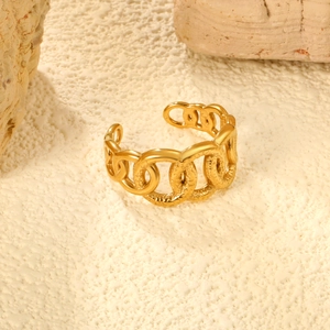 Close-up of golden chunky chain link ring with hammered texture on stone background