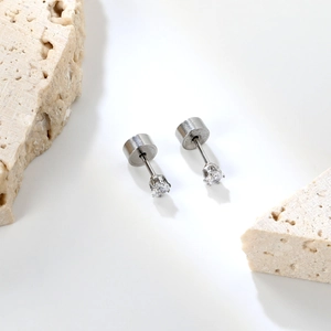 Détail de boucles d'oreilles clous en zircone ronde sur pierre blanche avec fermoir métal