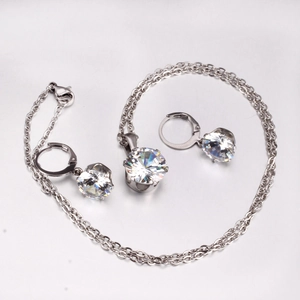 Detailed view of silver six-prong jewelry set featuring round cut zircon pendant and earrings