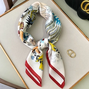 Artistic silk scarf detail with red rolled edges and whimsical feather illustrations