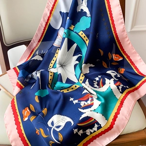 Detail of artistic floral pattern with white doves on silky blue square scarf draped on a chair