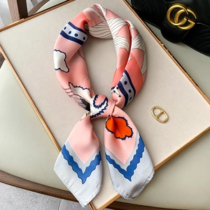 Detail of silk-like neckerchief with pink and blue geometric patterns tied in a knot