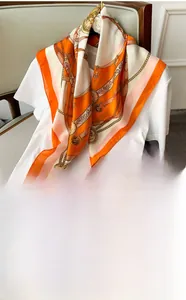Detail of 70x70cm vintage silk scarf with orange chain print styled on a white shirt