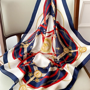 Detailed view of satin silk scarf with equestrian chain patterns and bear emblem drape