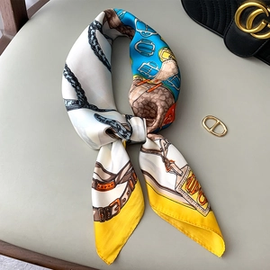Elegant silk scarf with horsebit chain pattern in yellow and blue, tied style