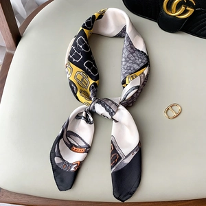 Macro detail of silk scarf with vintage chain and gold buckle pattern on a beige seat