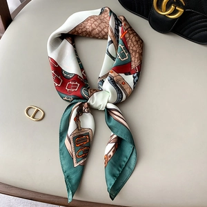 Detailed view of silk-like scarf with vintage chain patterns and satin texture finish
