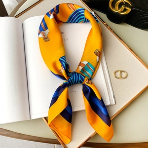 Close-up of orange silk scarf with blue stripes and belt patterns on a fashion magazine