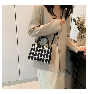 Détail du sac à bandoulière en tweed noir et blanc avec ferrures dorées et sangle en cuir