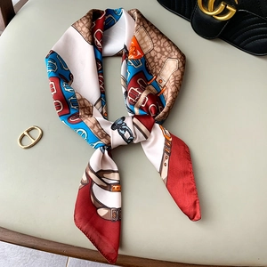 Luxurious chain and belt pattern silk-like square scarf styled on a premium leather surface