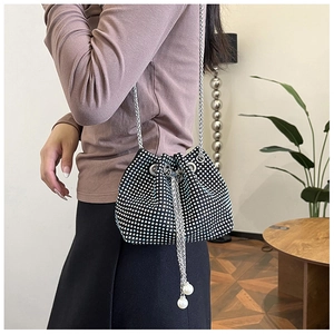 Détail du sac seau en strass avec cordon en perles et bandoulière en chaîne argentée