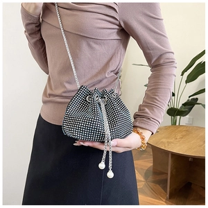 Détail du sac seau en strass avec fermeture par cordon et élégants accents de perles