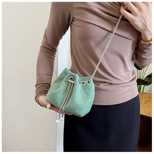Détail du sac seau vert menthe à strass avec chaîne en métal et cordon de serrage perlé