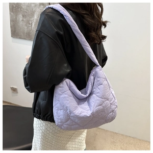 Detail of lavender heart-quilted puffer bag showing shoulder strap and fabric texture