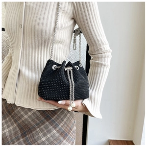 Détail du sac seau noir en strass avec bandoulière chaîne argentée et glands en perles
