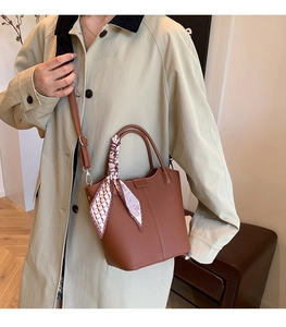 Brown bucket bag with lychee texture and floral silk scarf detail on handle