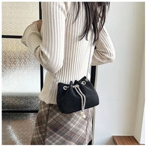 Détail du sac seau noir avec strass, chaîne argentée et breloques en perles