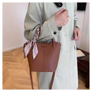 Brown lychee leather bucket bag with printed silk scarf wrap on the handle detail